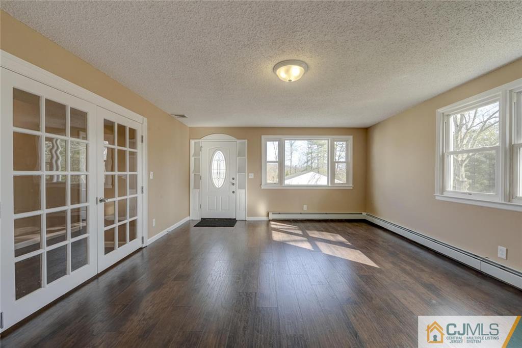 202 Higgins Road Old Bridge, NJ 07747 - Photo 5 of 25 a view of an empty room with a window and wooden floor
