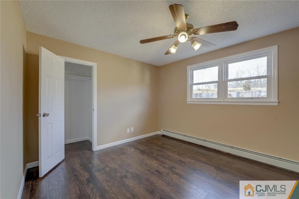 202 Higgins Road Old Bridge, NJ 07747 - Photo 6 of 25 a view of an empty room with wooden floor and a window