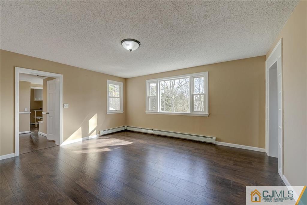 202 Higgins Road Old Bridge, NJ 07747 - Photo 7 of 25 an empty room with wooden floor and windows