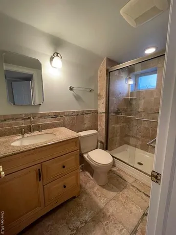 a bathroom with a toilet a sink and glass door
