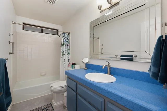 a bathroom with a sink toilet a mirror and shower