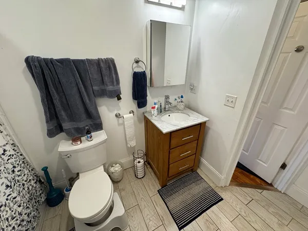a bathroom with a toilet a sink and a mirror