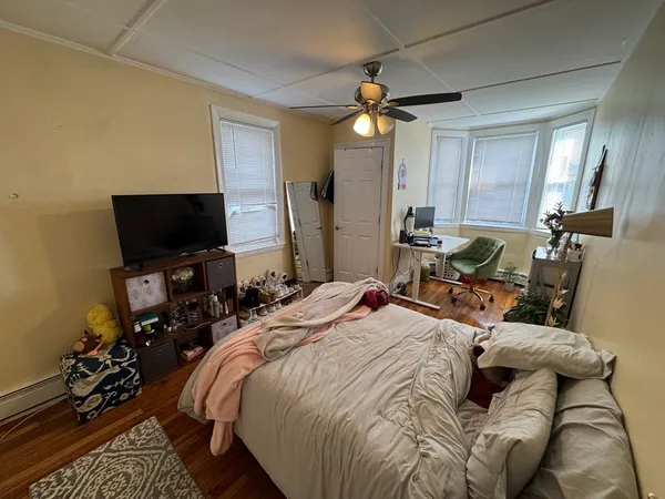 a bed room with a bed window and a flat screen tv