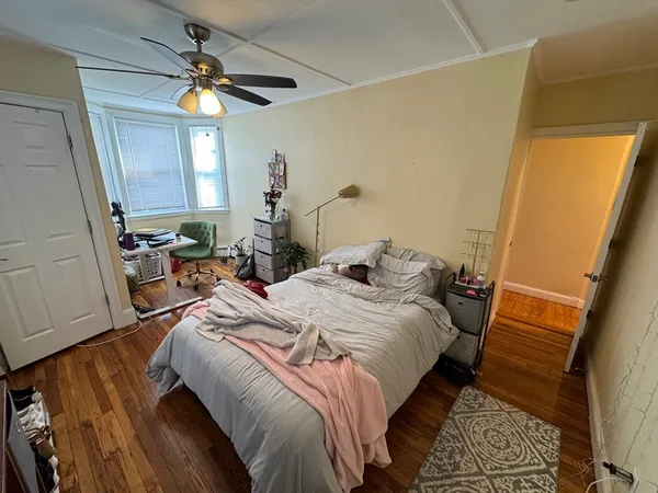 a bedroom with a bed and a mirror on the dresser