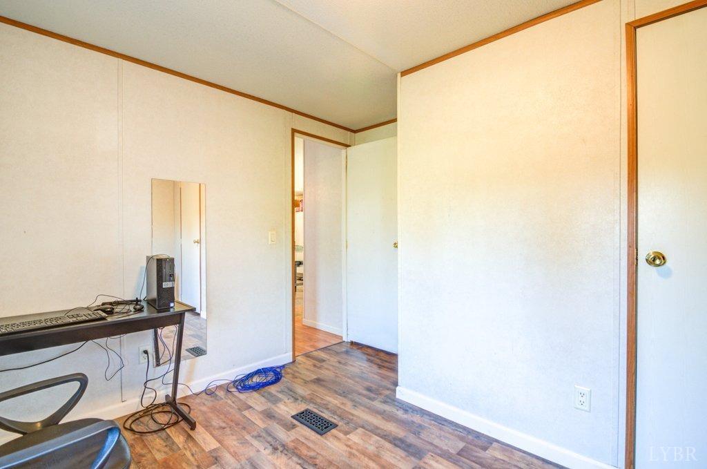 5029 Elon Road Monroe, VA 24574 - Photo 14 of 25 a view of a hallway with wooden floor and a bathroom