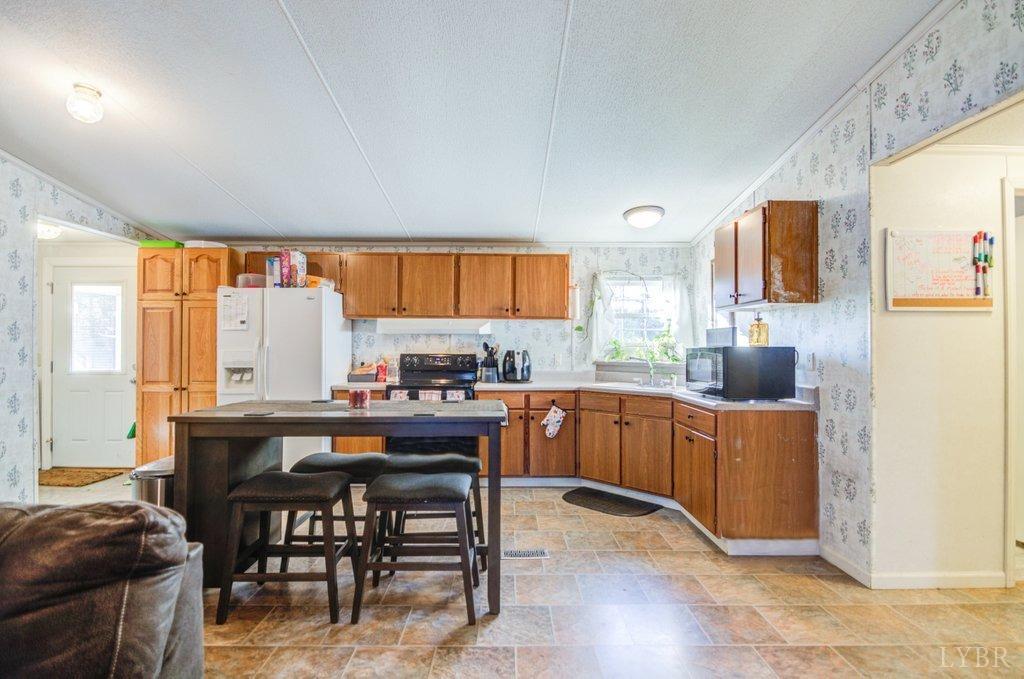 5029 Elon Road Monroe, VA 24574 - Photo 5 of 25 a kitchen with stainless steel appliances a table and chairs in it