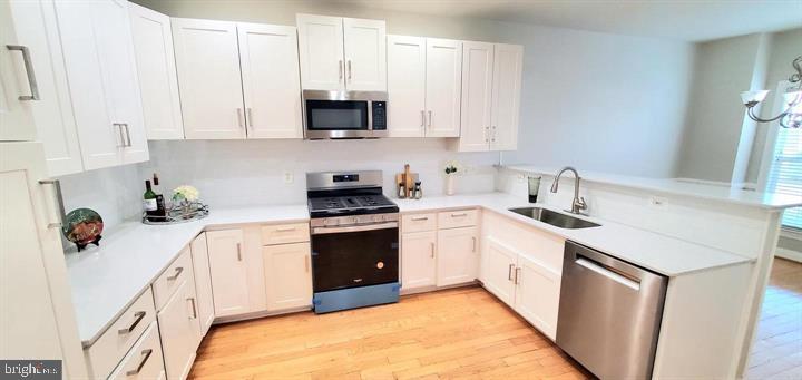 20153 Valhalla Square Ashburn, VA 20147 - Photo 11 of 26 a kitchen with stainless steel appliances a sink stove and cabinets