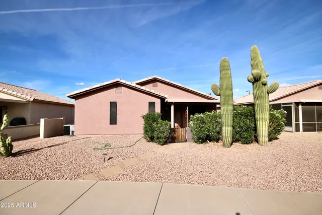 a front view of a house with a yard and potted plants