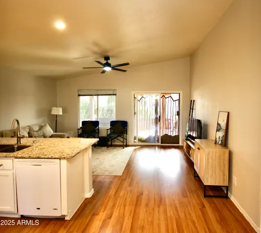 a view of a livingroom with furniture hardwood floor and a ceiling fan