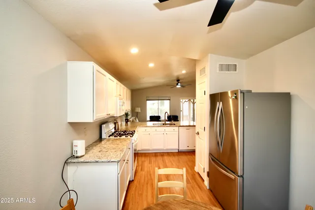 a kitchen with granite countertop a refrigerator and a sink