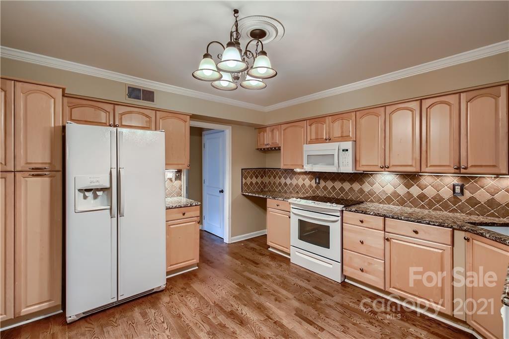 7040 Quail Hill Road Charlotte, NC 28210 - Photo 13 of 33 a kitchen with stainless steel appliances granite countertop a refrigerator a sink dishwasher a stove and white cabinets with wooden floor