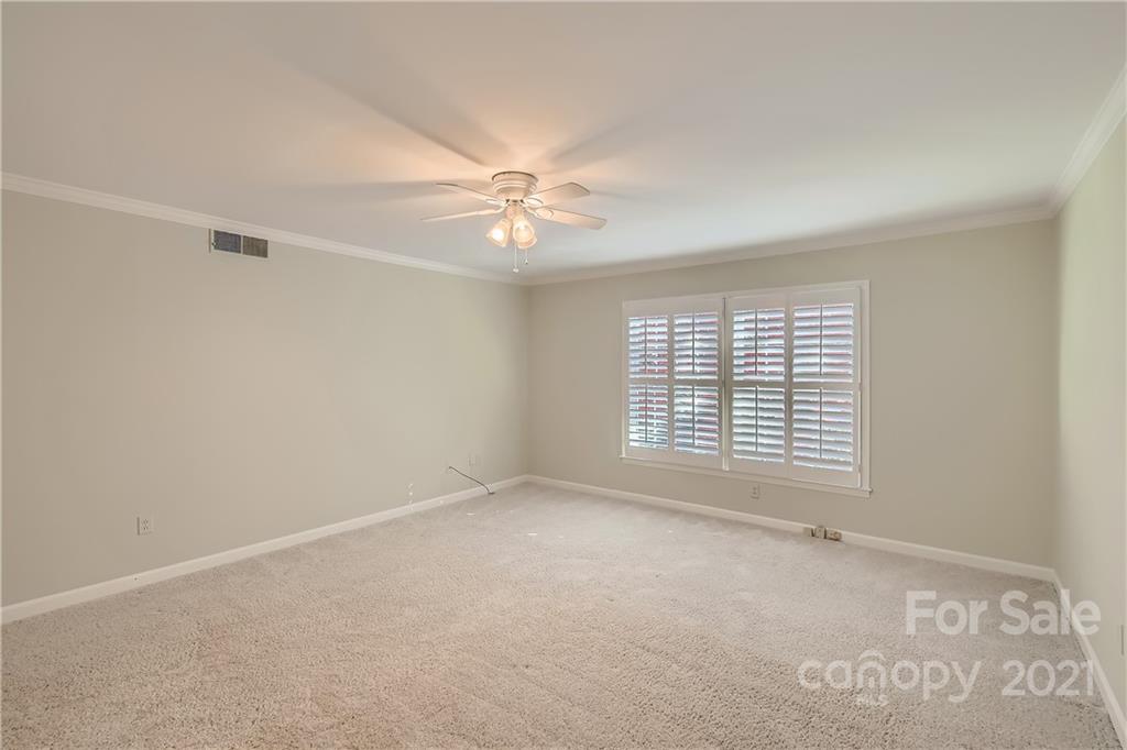 7040 Quail Hill Road Charlotte, NC 28210 - Photo 20 of 33 an empty room with chandelier fan and windows