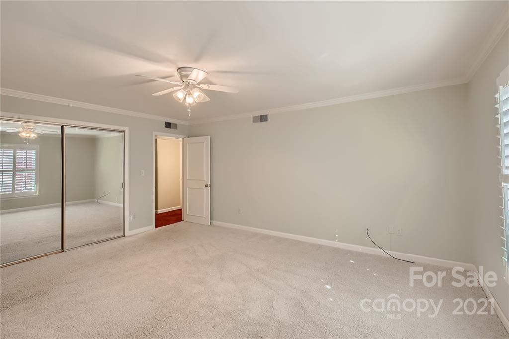 7040 Quail Hill Road Charlotte, NC 28210 - Photo 21 of 33 an empty room with a ceiling fan and a window