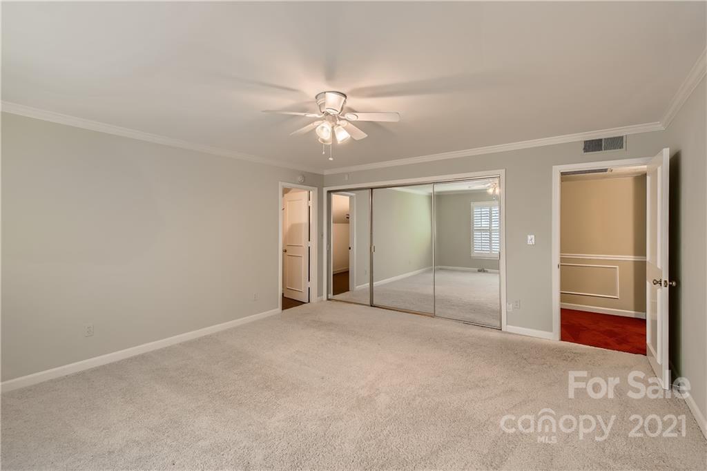 7040 Quail Hill Road Charlotte, NC 28210 - Photo 22 of 33 an empty room with chandelier fan and windows