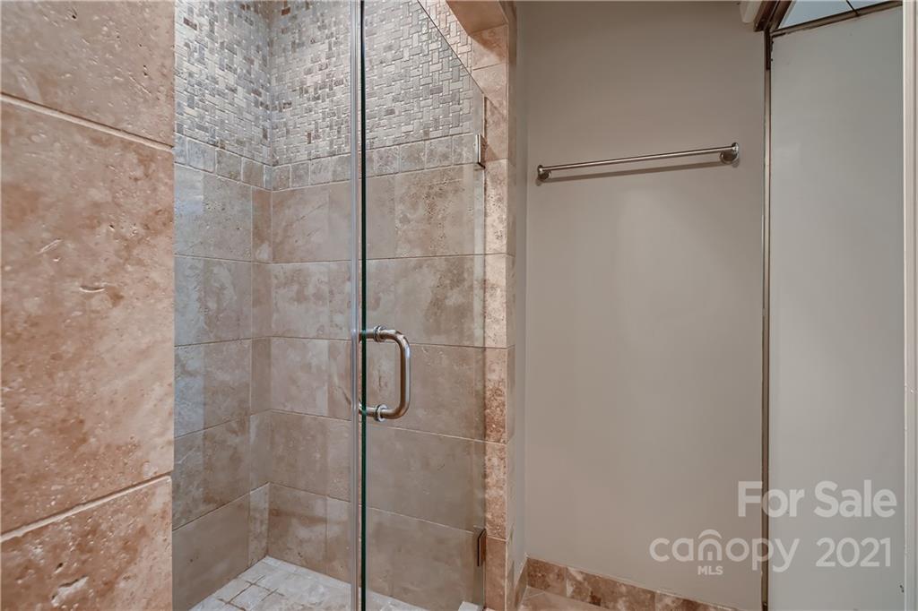 7040 Quail Hill Road Charlotte, NC 28210 - Photo 23 of 33 a bathroom with a glass shower door