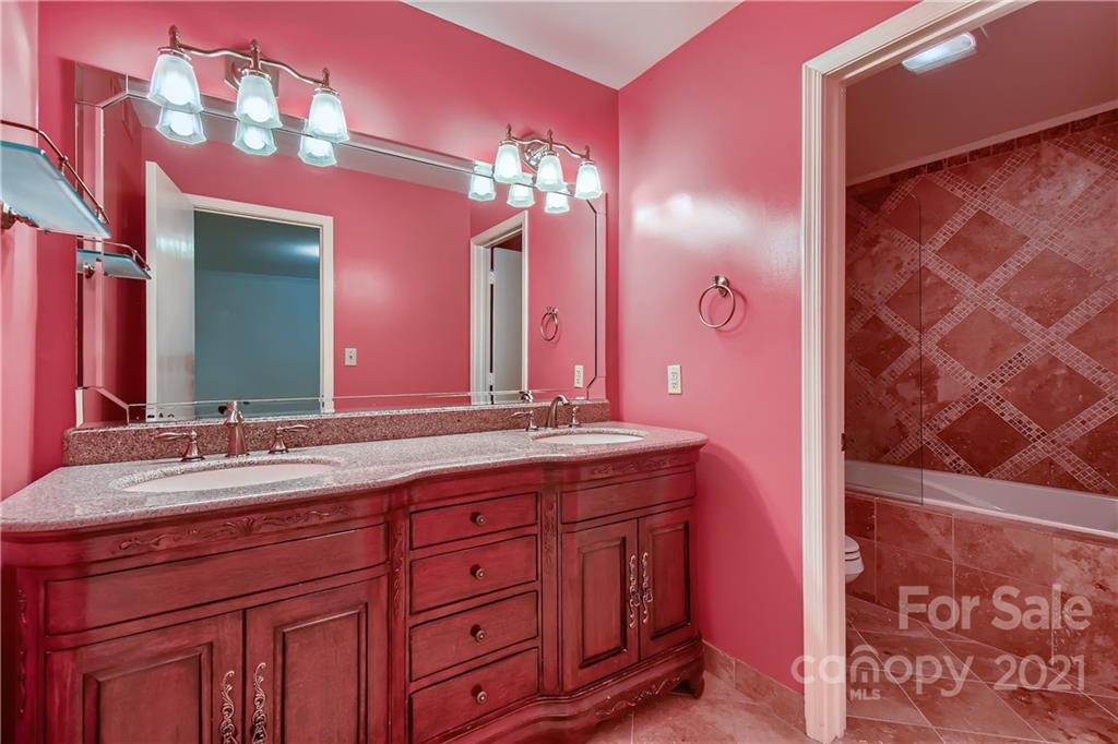 7040 Quail Hill Road Charlotte, NC 28210 - Photo 26 of 33 a bathroom with a granite countertop sink a large mirror and a shower