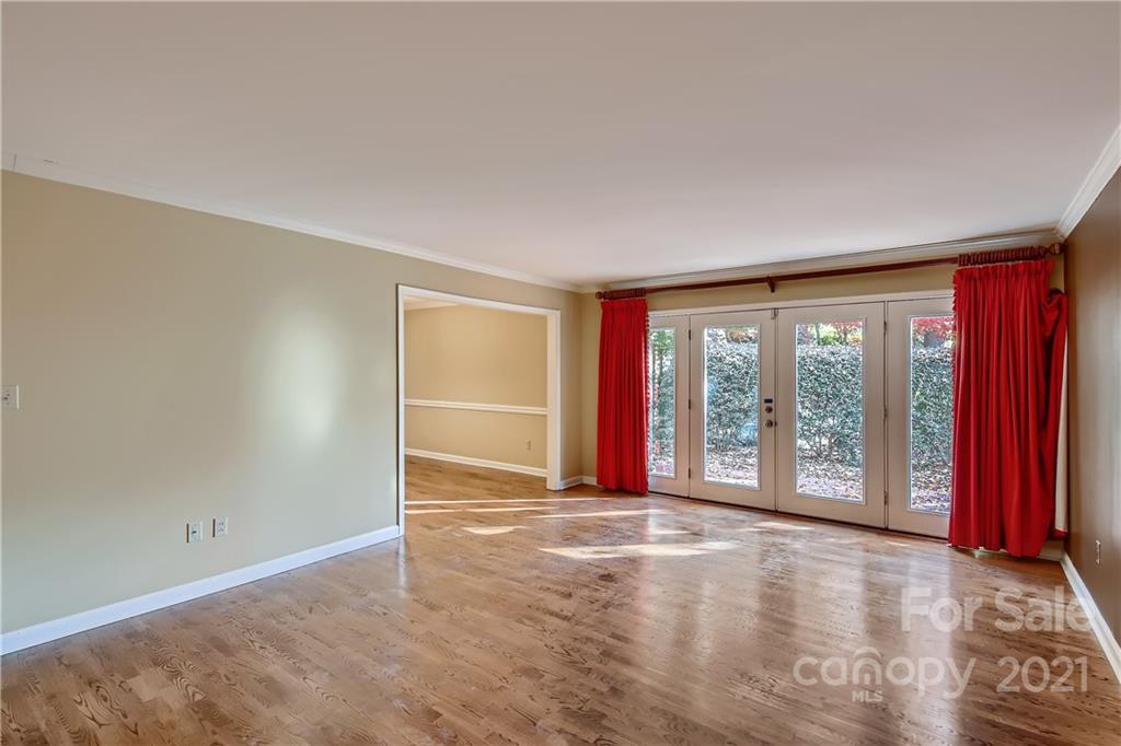 7040 Quail Hill Road Charlotte, NC 28210 - Photo 4 of 33 an empty room with wooden floor and windows with curtains view