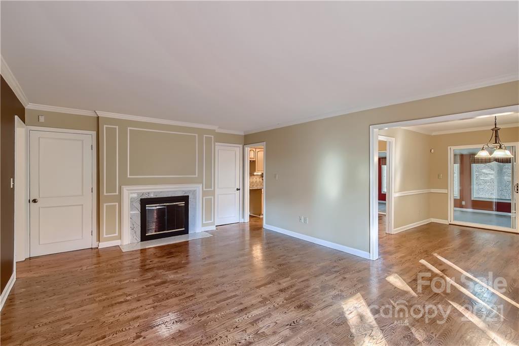 7040 Quail Hill Road Charlotte, NC 28210 - Photo 5 of 33 a view of empty room with wooden floor and fireplace