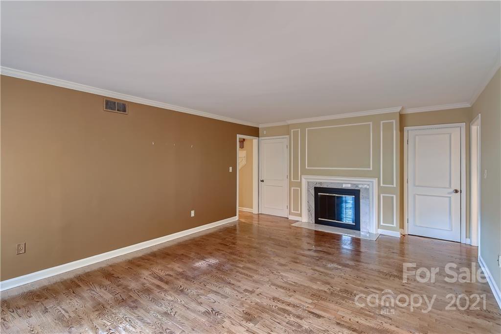 7040 Quail Hill Road Charlotte, NC 28210 - Photo 6 of 33 a view of empty room with wooden floor and fireplace