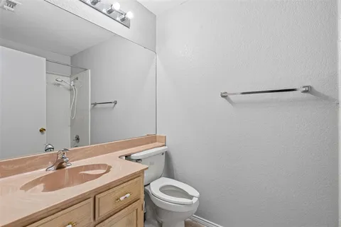 a bathroom with a granite countertop sink a toilet and a mirror