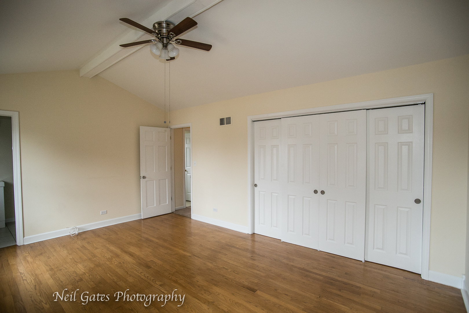 586 Roxbury Drive Naperville, IL 60565 - Photo 27 of 39 a view of a room with wooden floor and a ceiling fan