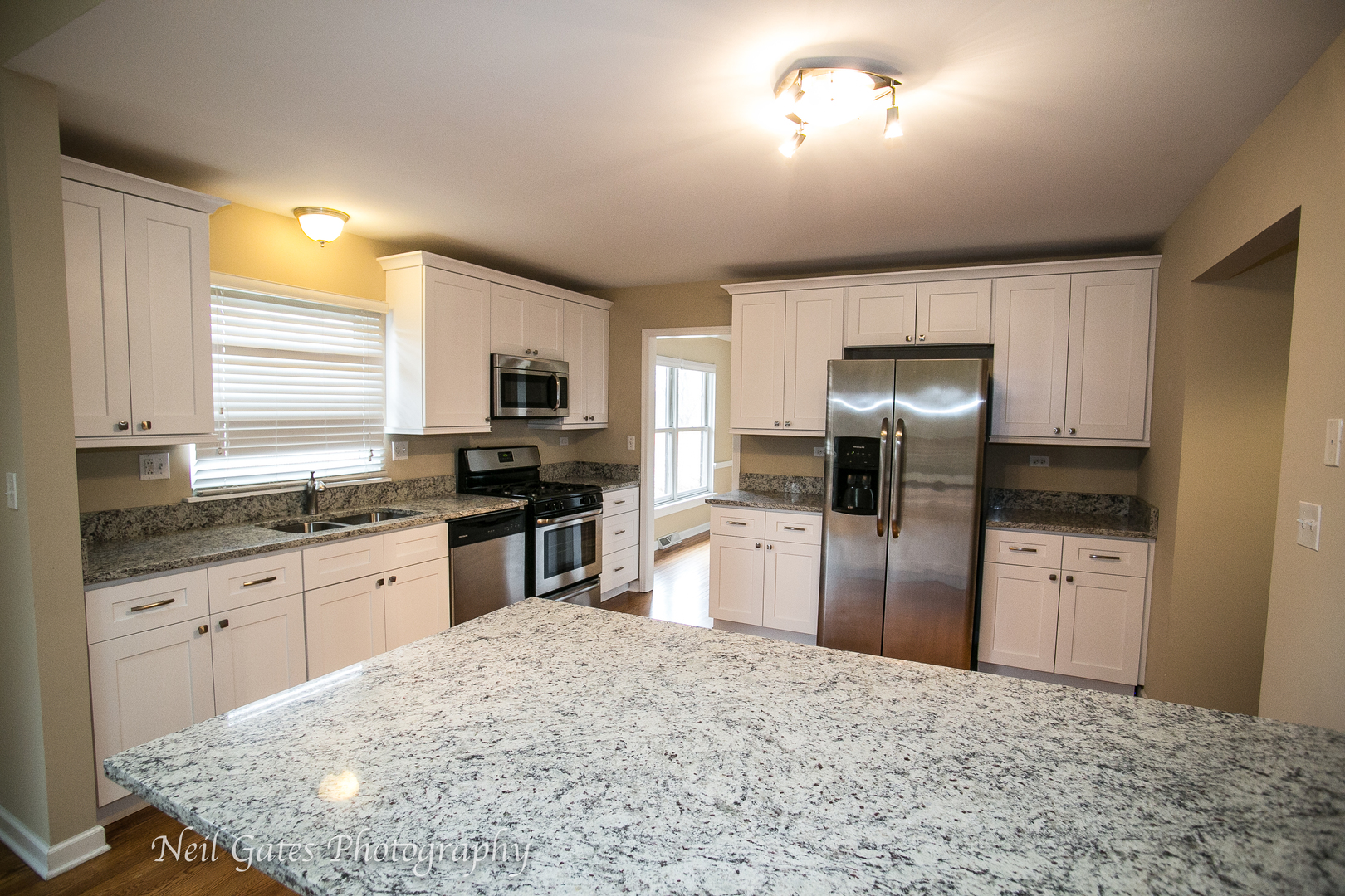586 Roxbury Drive Naperville, IL 60565 - Photo 7 of 39 a kitchen with granite countertop a refrigerator and a stove top oven