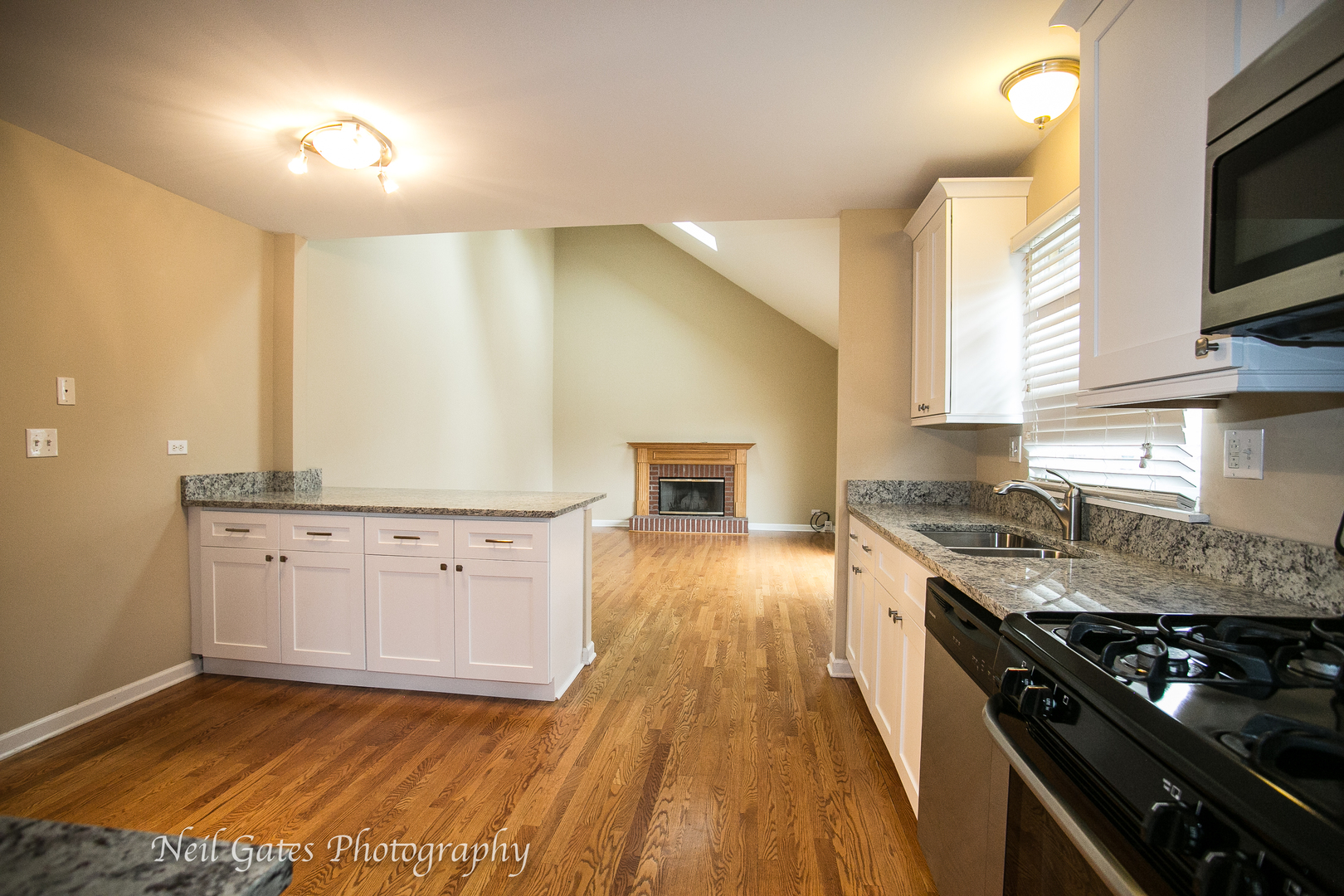 586 Roxbury Drive Naperville, IL 60565 - Photo 10 of 39 a kitchen with granite countertop a stove a sink and a microwave