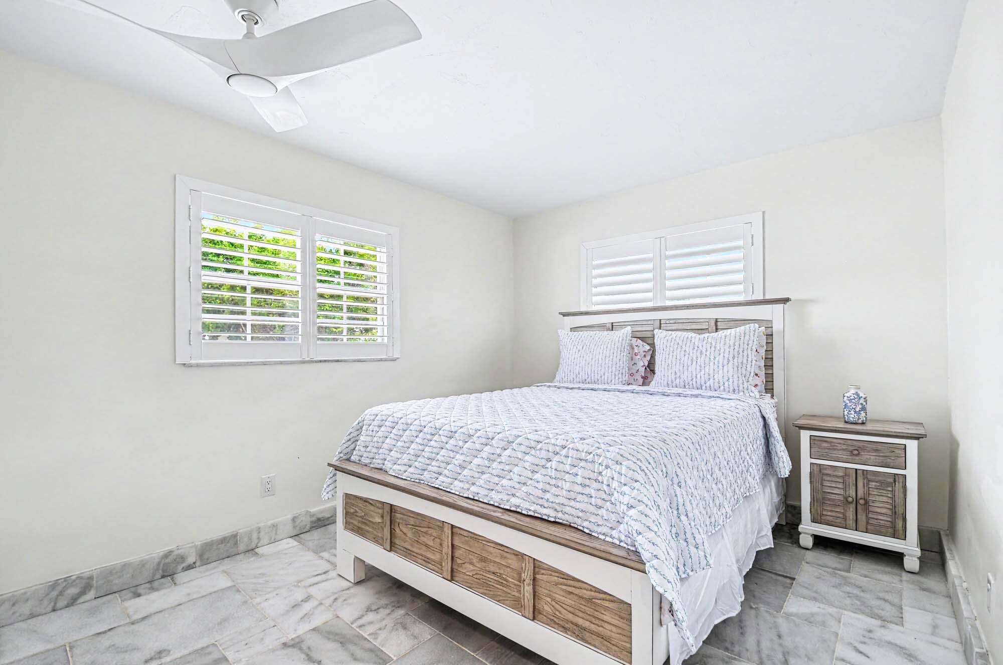 112 Capri Boulevard Naples, FL 34113 - Photo 15 of 29 a bedroom with a bed and a window