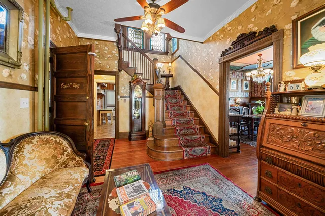 a living room with furniture a chandelier and a large mirror