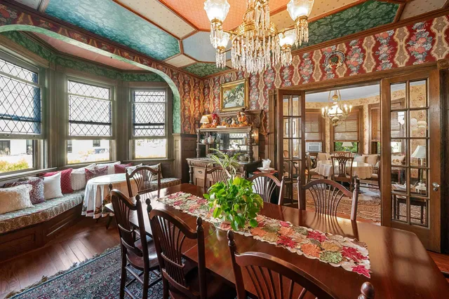 a view of a dining room with furniture a chandelier and wooden floor