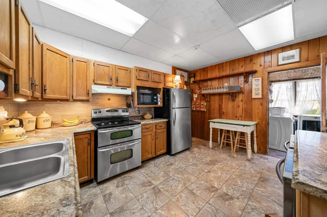a kitchen with stainless steel appliances granite countertop sink stove and refrigerator