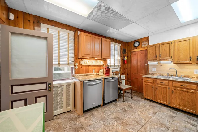 a kitchen with stainless steel appliances granite countertop a refrigerator a stove top oven a sink and dishwasher