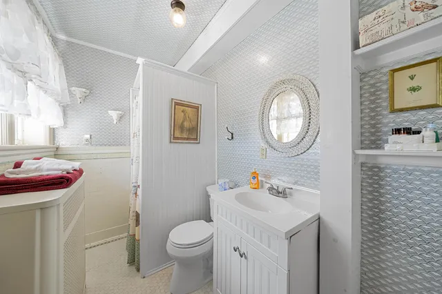 a bathroom with a toilet a sink and a mirror