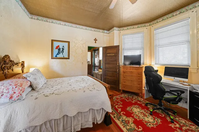 a bedroom with a bed and wooden floor