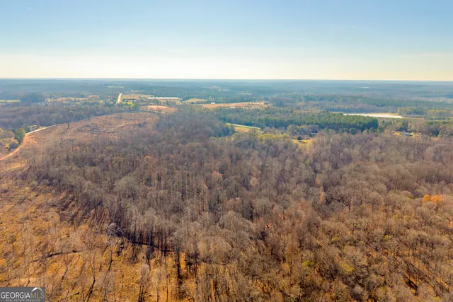 a view of an empty room with a window and a living room
