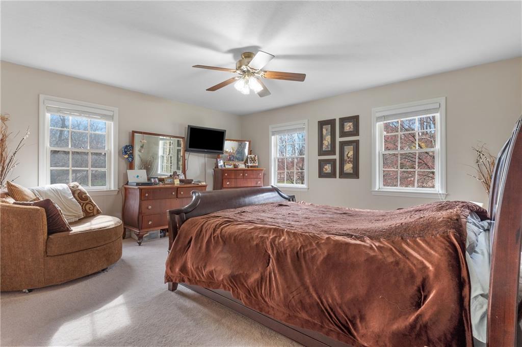 207 Oak Leaf Drive Mars, PA 16046 - Photo 18 of 40 a spacious bedroom with a bed a couch and a large window
