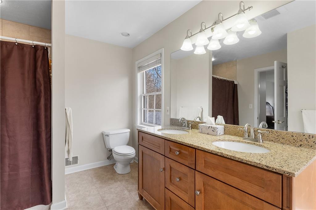 207 Oak Leaf Drive Mars, PA 16046 - Photo 33 of 40 a bathroom with a granite countertop sink a toilet and a large mirror