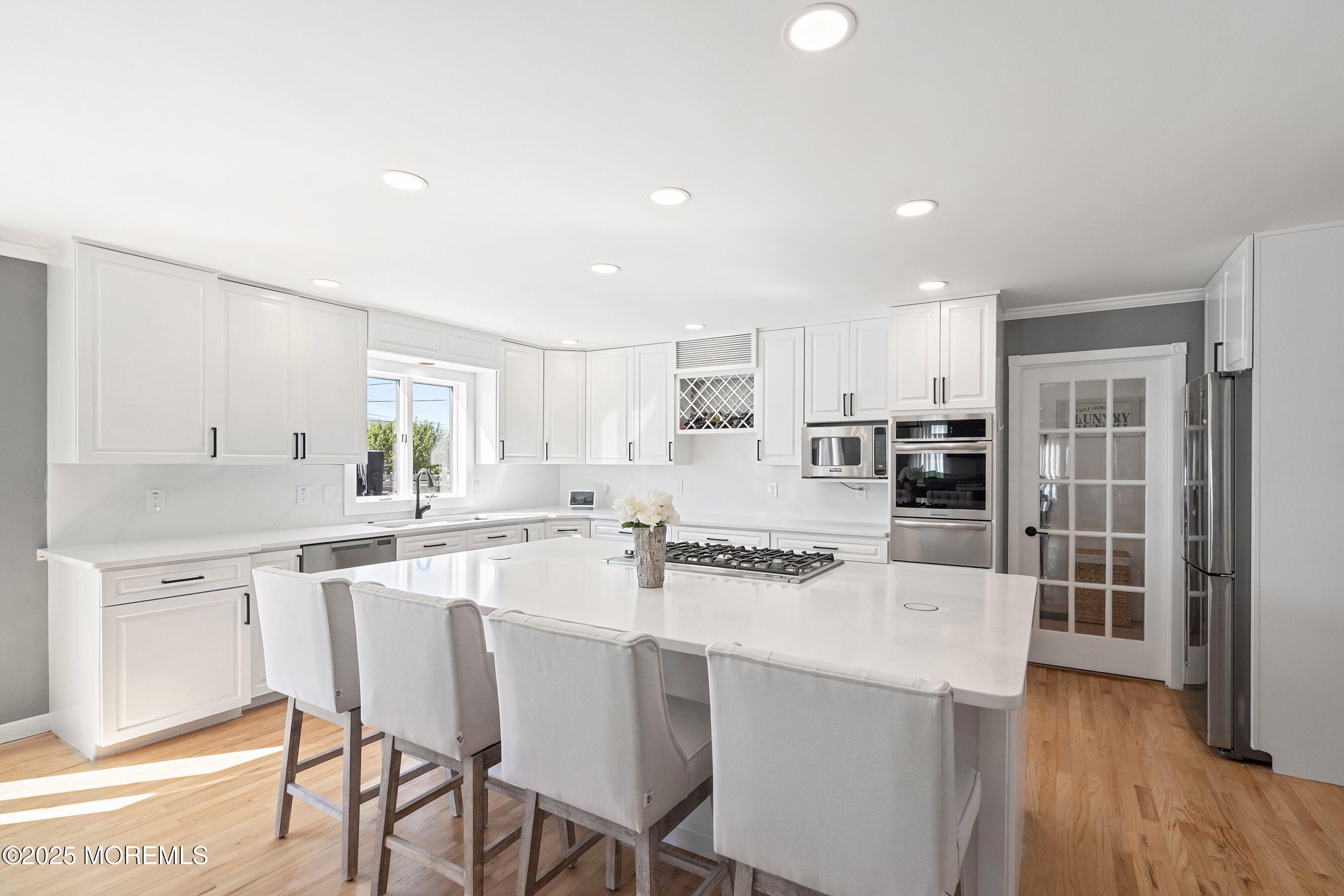 1615 Calamus Place Point Pleasant, NJ 08742 - Photo 16 of 62 a kitchen with stainless steel appliances a dining table chairs and wooden floor