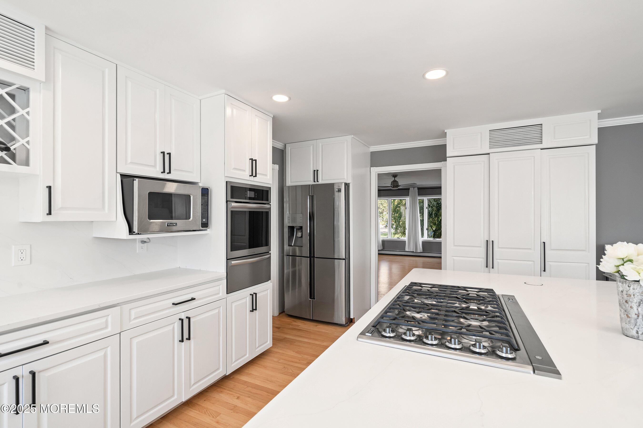 1615 Calamus Place Point Pleasant, NJ 08742 - Photo 17 of 62 a kitchen with stainless steel appliances granite countertop a refrigerator oven a sink dishwasher and white cabinets with wooden floor