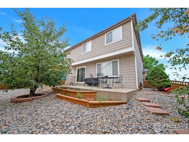 a view of a house with backyard and sitting area