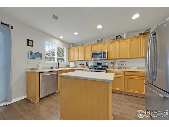 a kitchen with a sink cabinets stainless steel appliances and a window