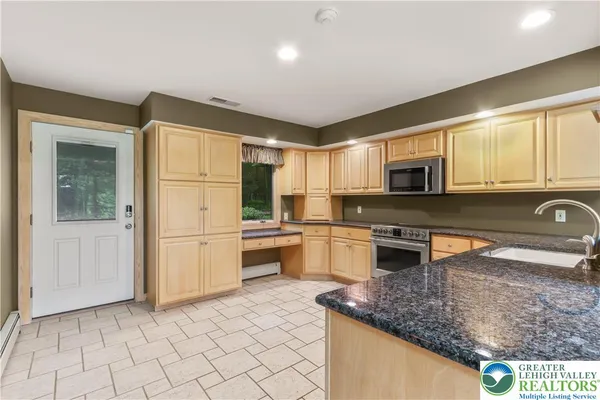 a kitchen with granite countertop a sink and a counter top space