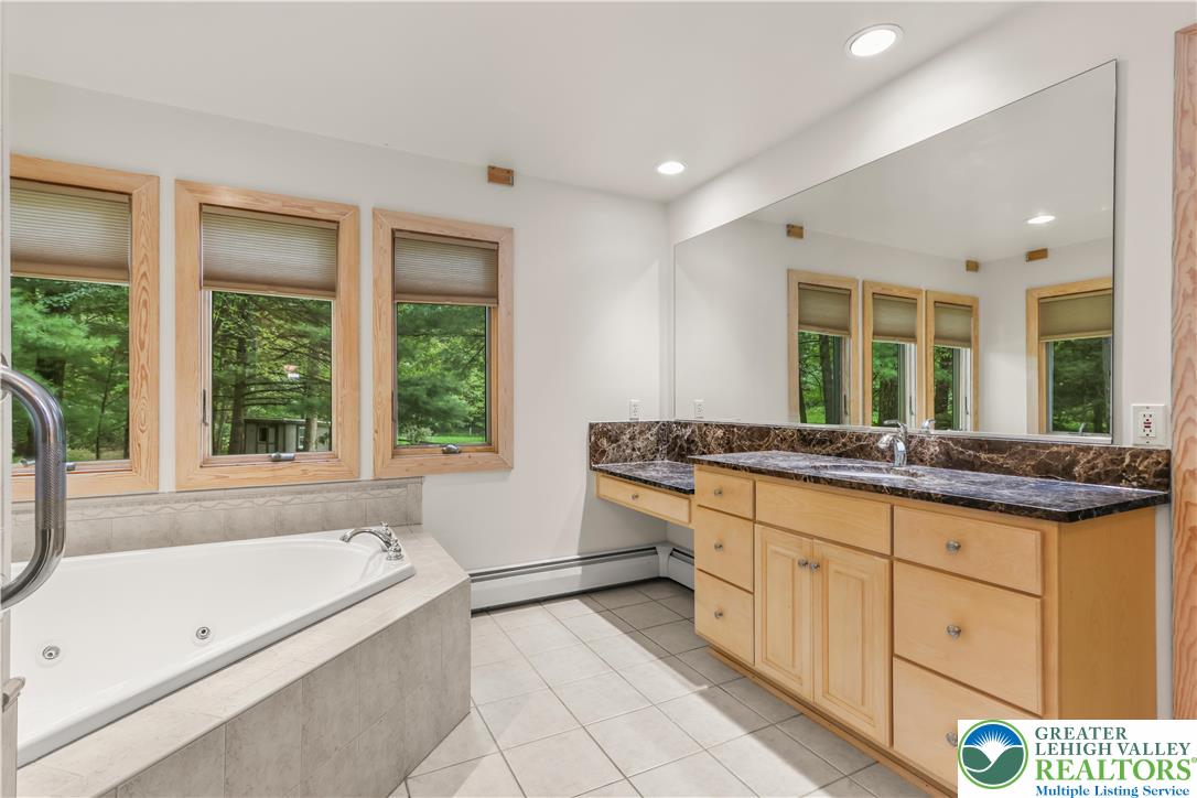 376 H T Y Road Kunkletown, PA 18058 - Photo 55 of 80 a bathroom with a granite countertop tub a sink and a large window