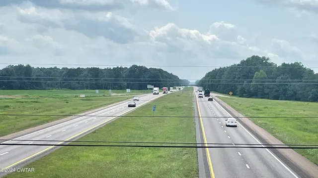 a view of a street with a yard and a house