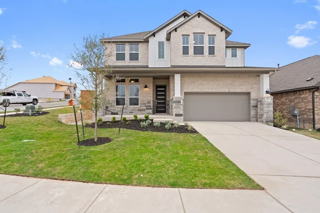 a front view of a house with a yard and garage