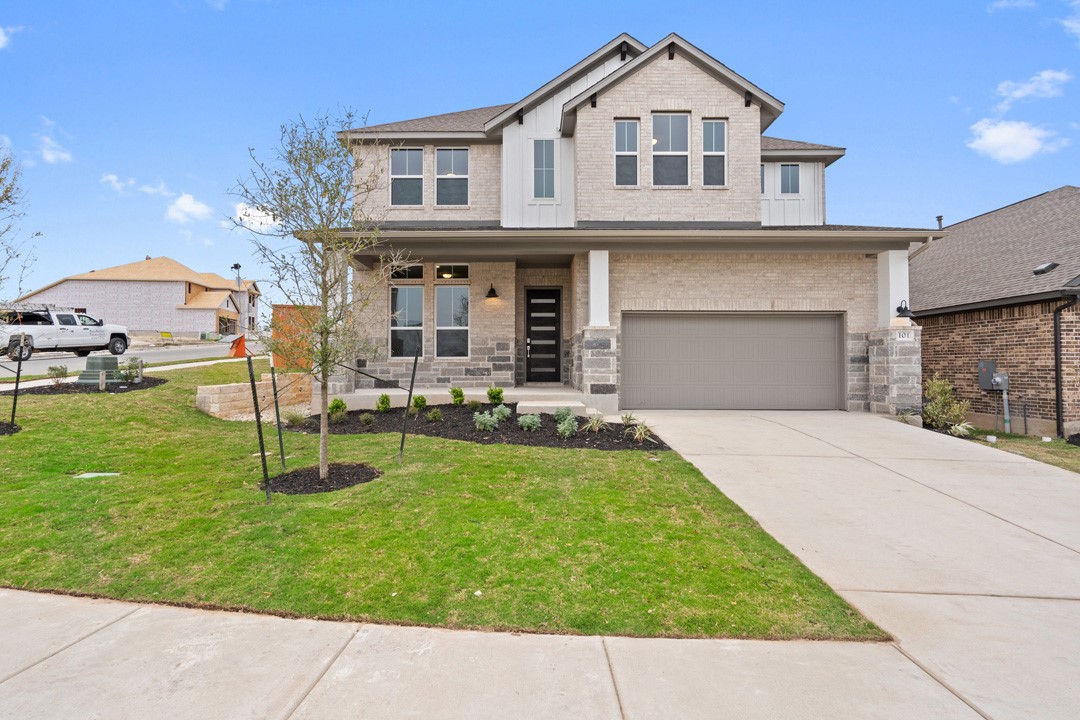 a front view of a house with a yard and garage