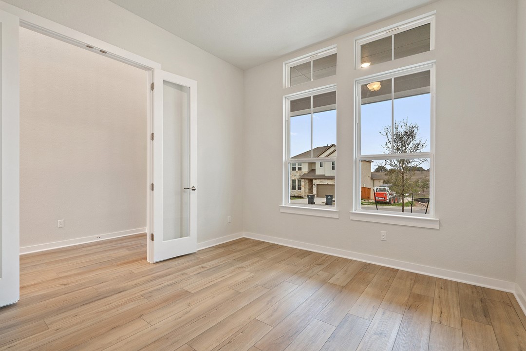 101 Old Wds Road Liberty Hill, TX 78642 - Photo 18 of 40 an empty room with wooden floor and windows