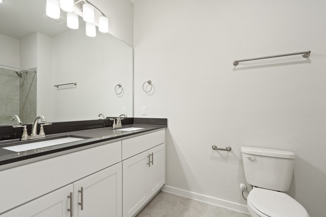 101 Old Wds Road Liberty Hill, TX 78642 - Photo 35 of 40 a bathroom with a granite countertop sink a toilet and a mirror