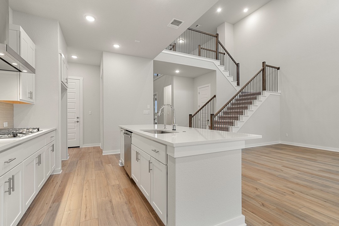101 Old Wds Road Liberty Hill, TX 78642 - Photo 8 of 40 a kitchen with granite countertop a sink and a stove top oven