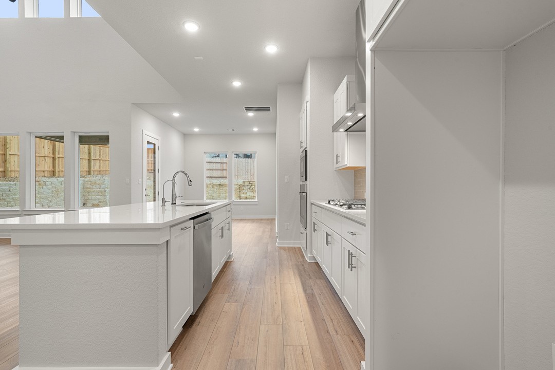 101 Old Wds Road Liberty Hill, TX 78642 - Photo 10 of 40 a large kitchen with a lot of counter space and wooden floor